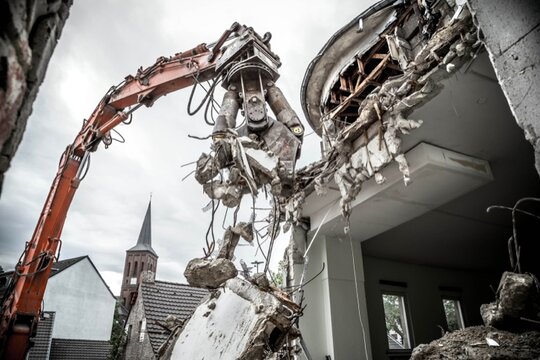 Hausrückbau Ein Bagger reißt ein Haus ein